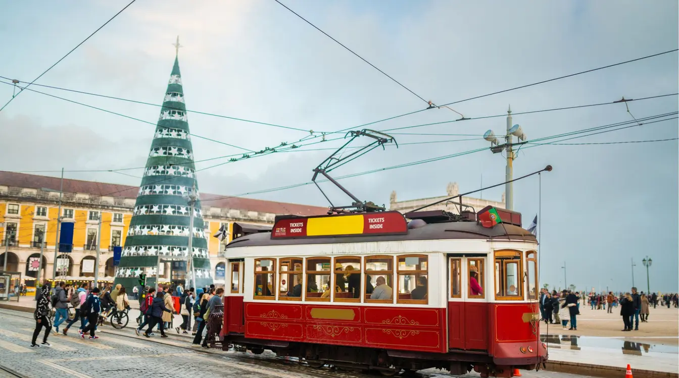 Bonde elétrico passando pela Praça do Comércio, ponto turístico de Lisboa.