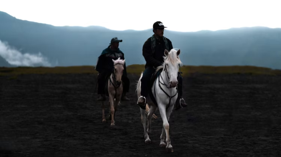 Two men riding horses on Mount Bromo
