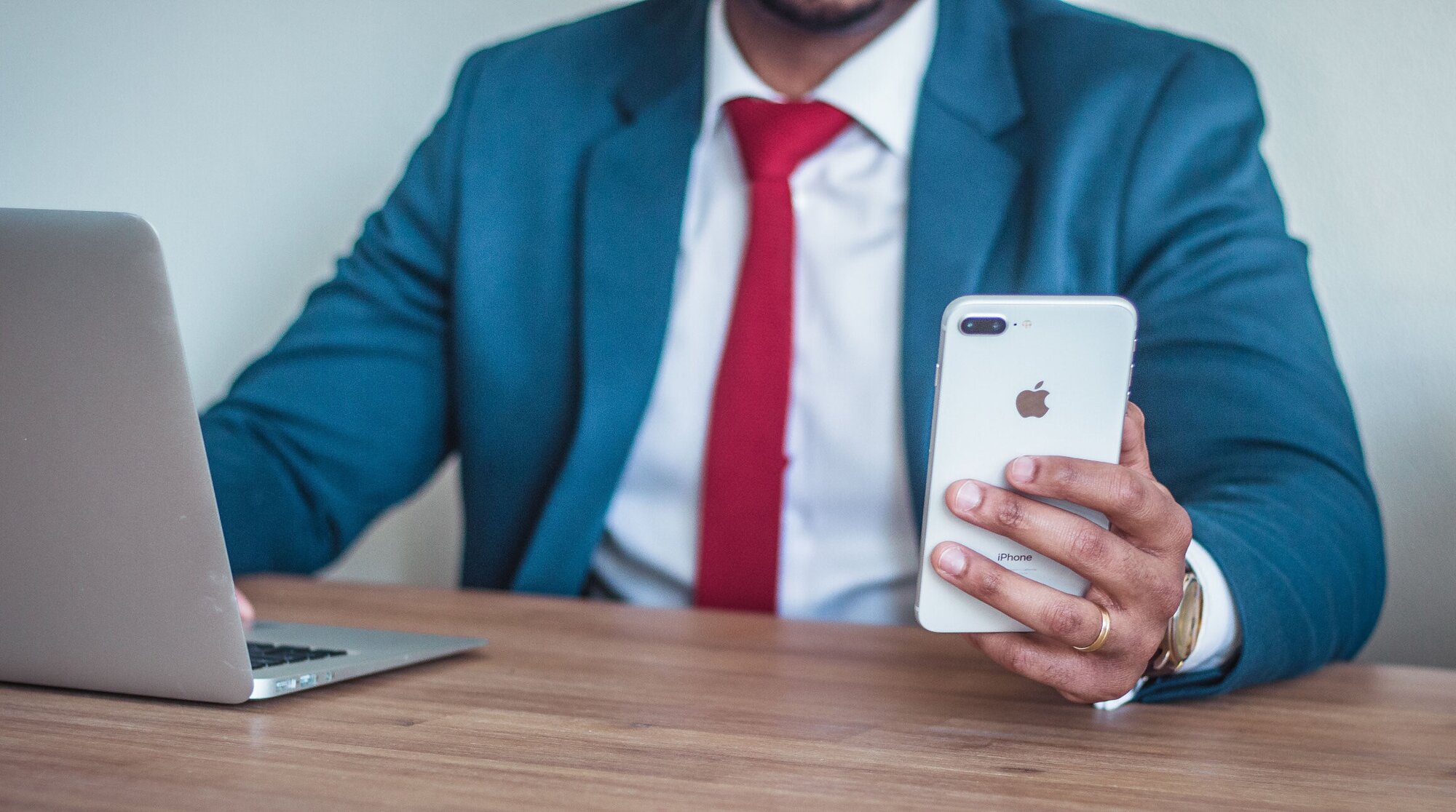 Man working on a laptop and using a smartphone