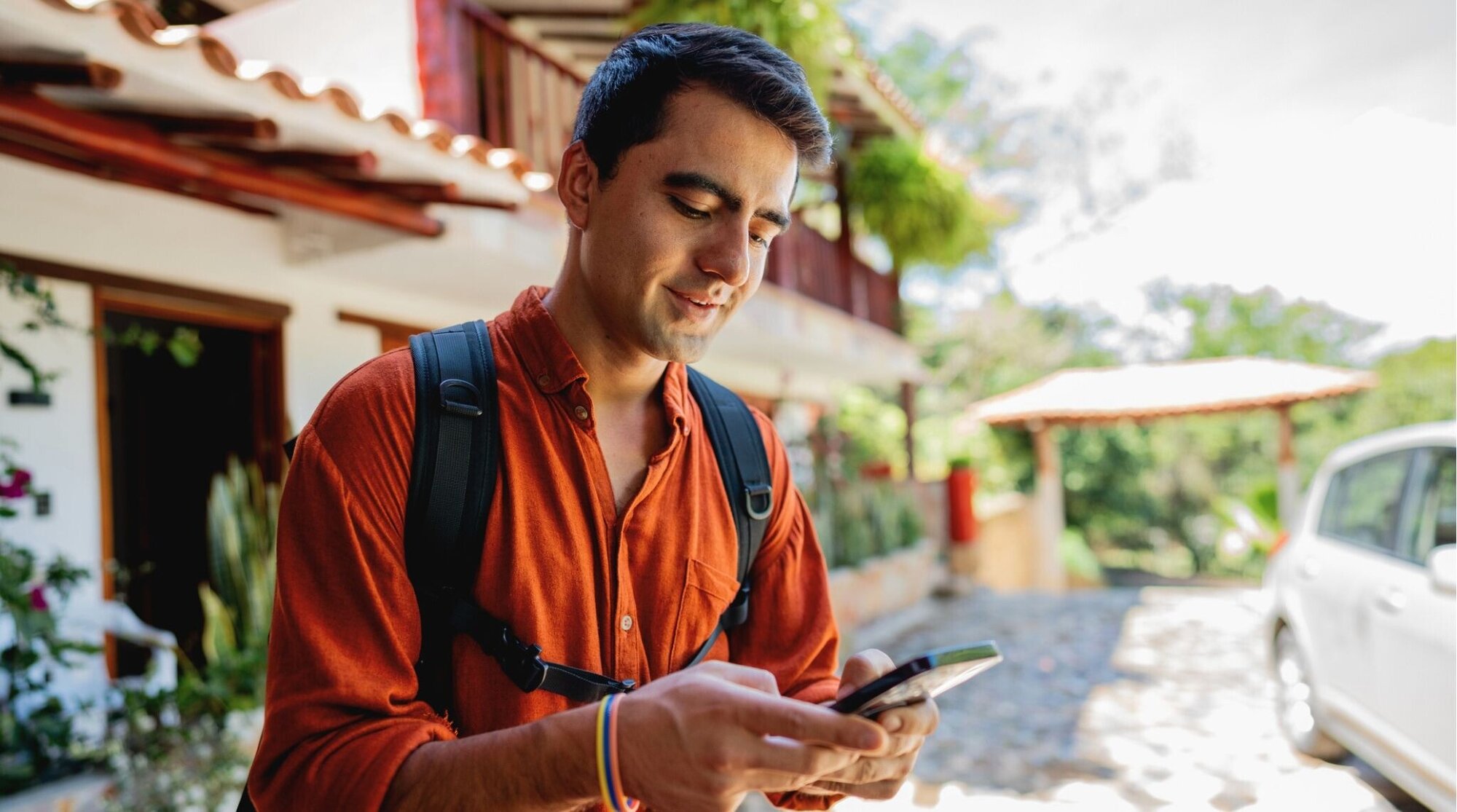 Viajero usando el móvil al aire libre, consultando preguntas frecuentes sobre compatibilidad eSIM.