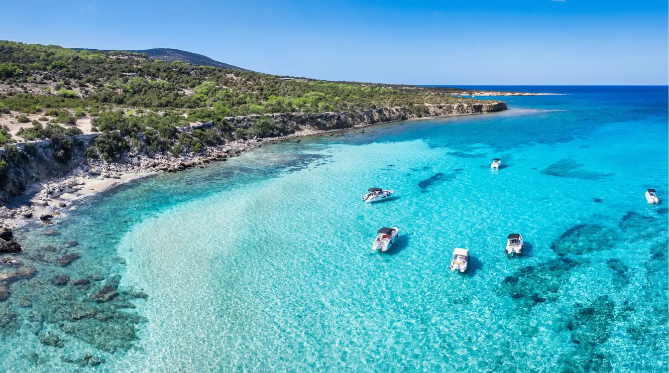 Vue aérienne du Blue Lagoon à Chypre, avec ses eaux turquoise, ses bateaux et la péninsule d'Akamas.
