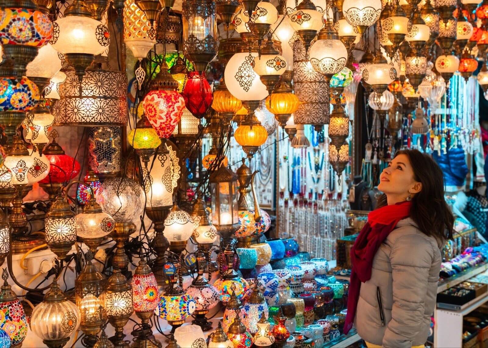  Touristin schlendert durch den bunten Großen Basar in Istanbul mit bunten Lampen