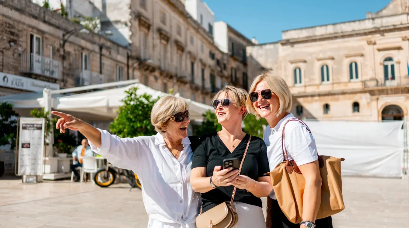 Três amigas explorando a Piazza della Libertà em Ostuni, a "cidade branca" da Puglia, no sul da Itália.