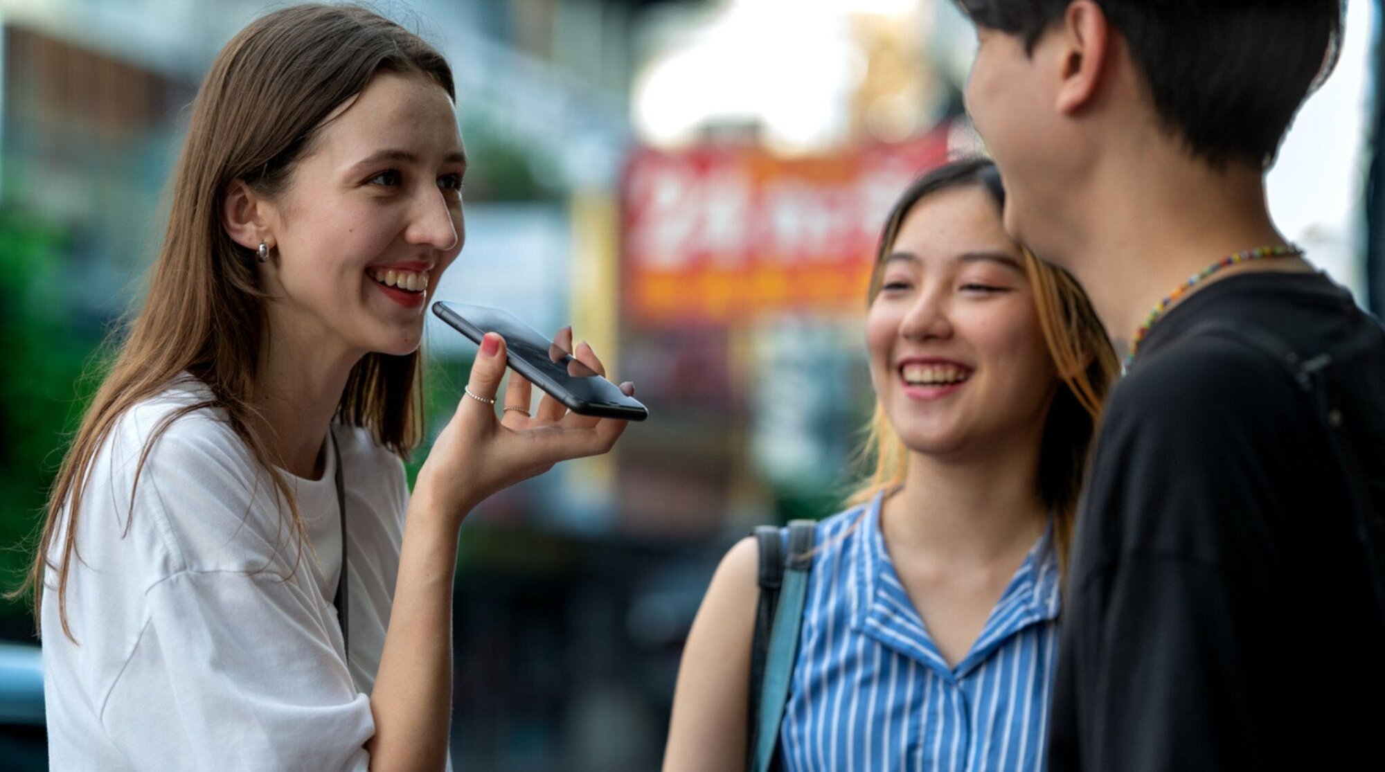 personnes utilisant une app de traduction vocale en voyage