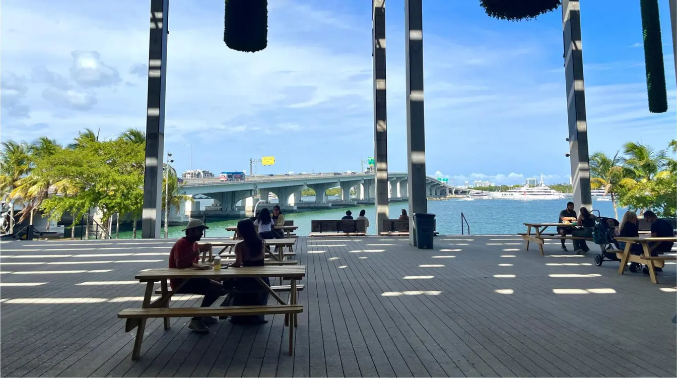 Turistas relaxando do lado de fora do Pérez Art Museum Miami, apreciando a vista da Baía de Biscayne.