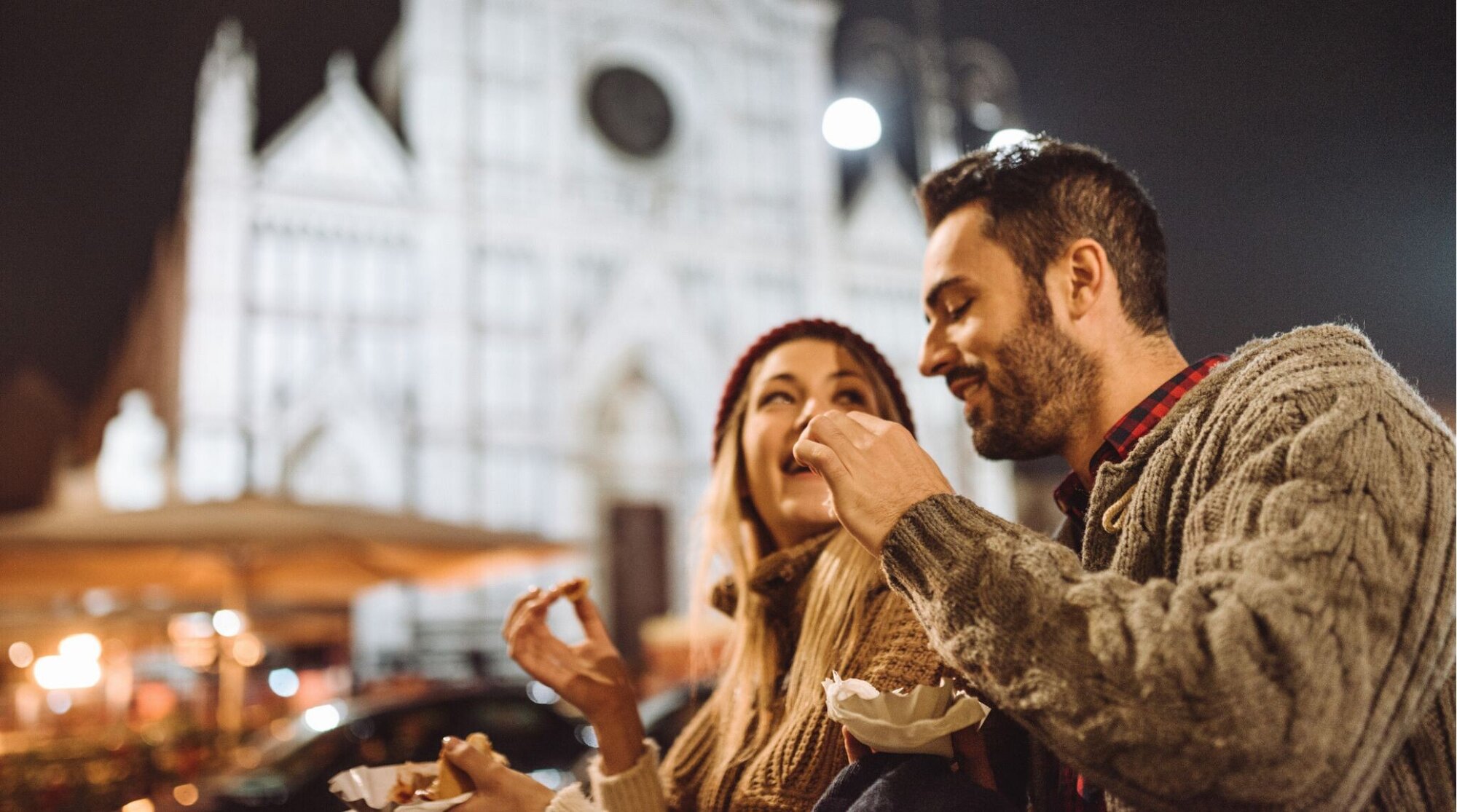 Casal experimentando comida de rua nos tradicionais mercados de Natal de Florença