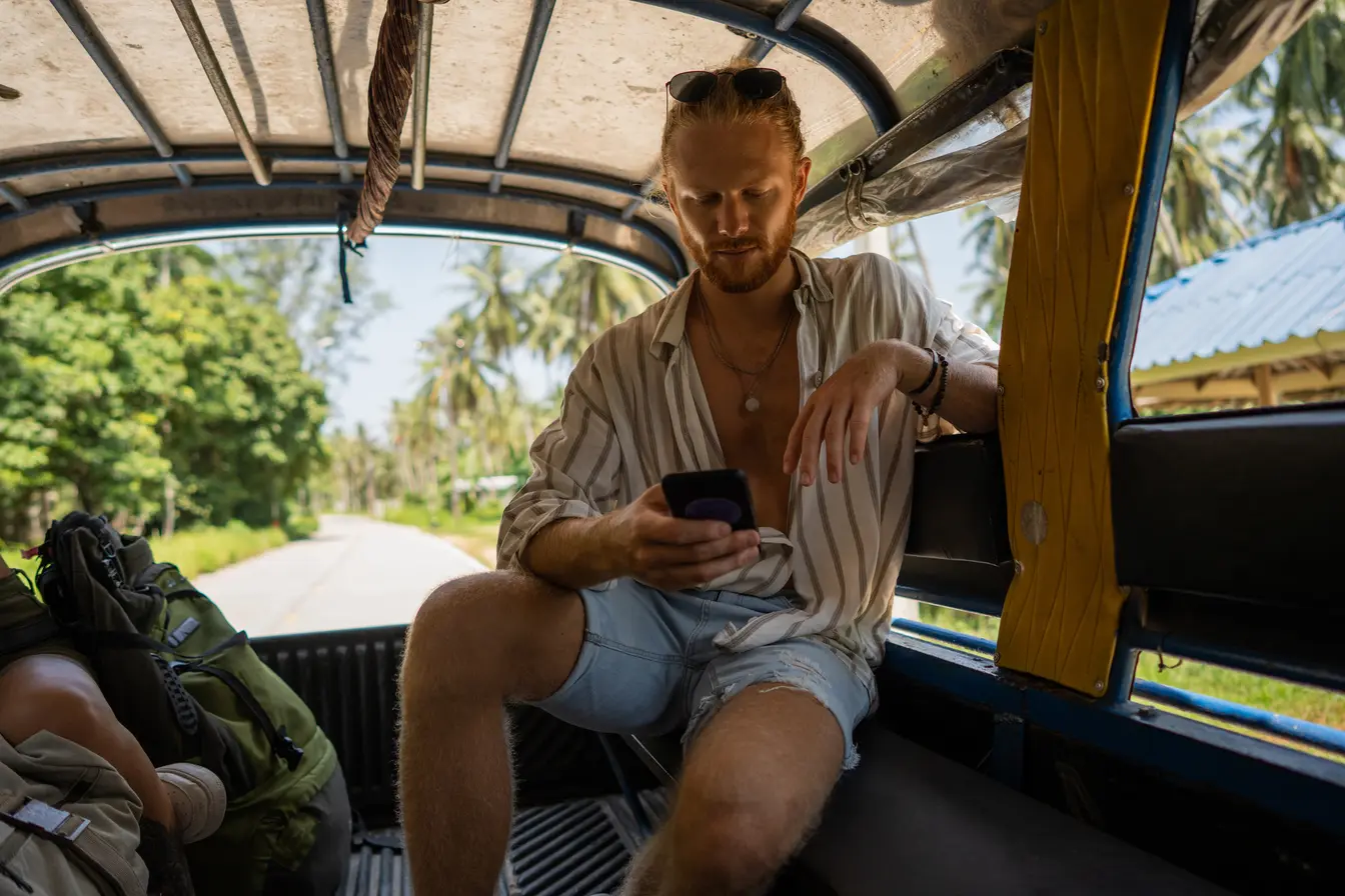 Turist i baksetet på en bil med eSIM for Thailand
