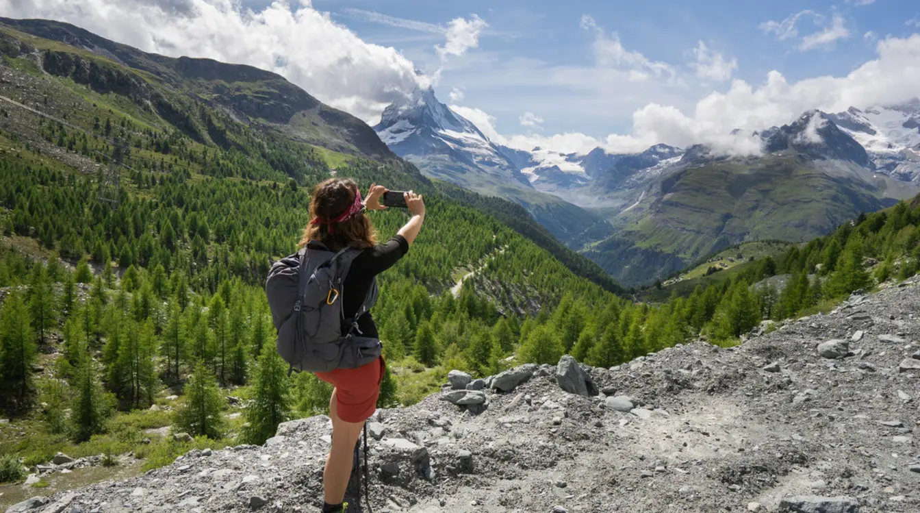 Eine Frau, die an einem sonnigen Sommertag mit ihrem Handy und einer eSIM den schönsten Berg der Schweiz, das Matterhorn, fotografiert.