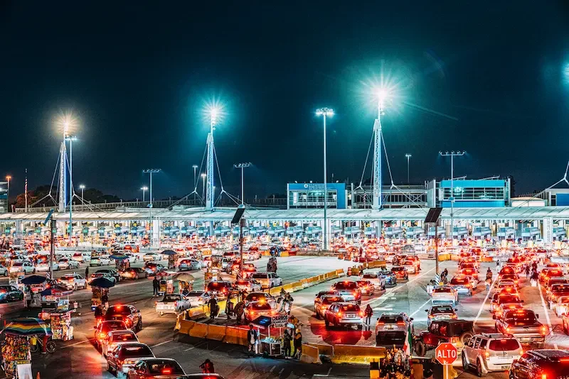 Fila de autos en un cruce fronterizo entre México y Estados Unidos, donde el roaming puede activarse antes de cruzar.