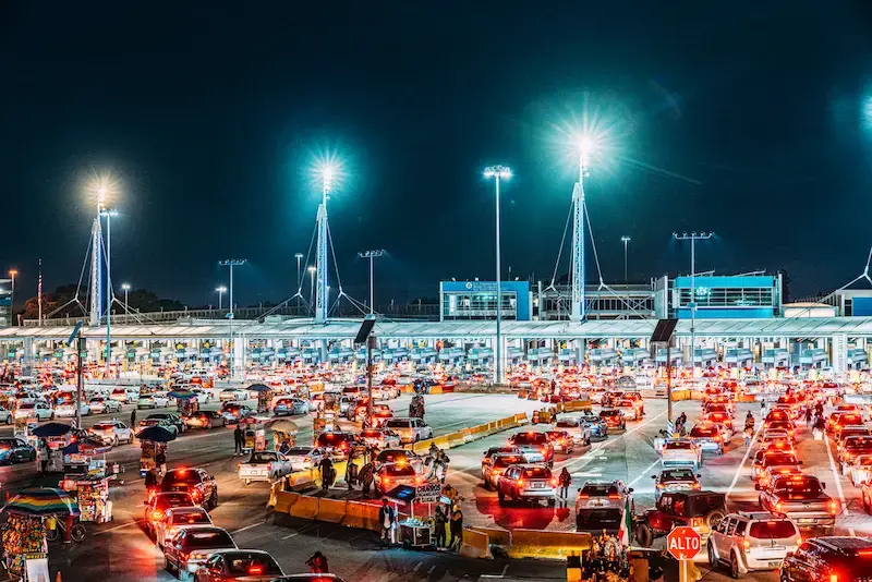 Fila de autos en un cruce fronterizo entre México y Estados Unidos, donde el roaming puede activarse antes de cruzar.