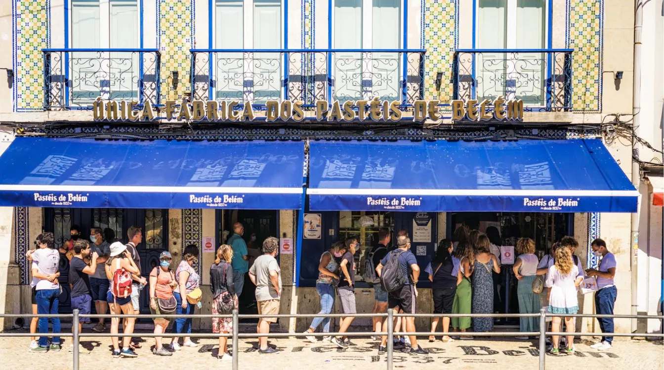 Pessoas fazendo fila fora da padaria Pasteis de Belém em Lisboa, Portugal