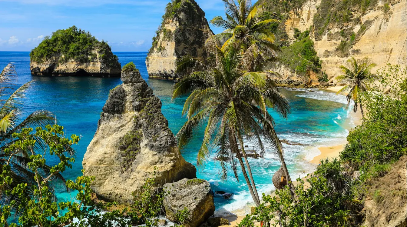 Vue sur Diamond Beach à Nusa Penida, Bali, avec sa plage de sable blanc, ses falaises calcaires et ses eaux turquoise.