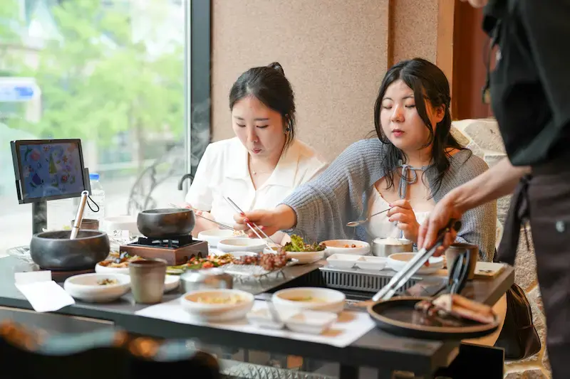 韓国旅行の注意点：韓国料理レストランで焼肉を楽しむ2名の女性