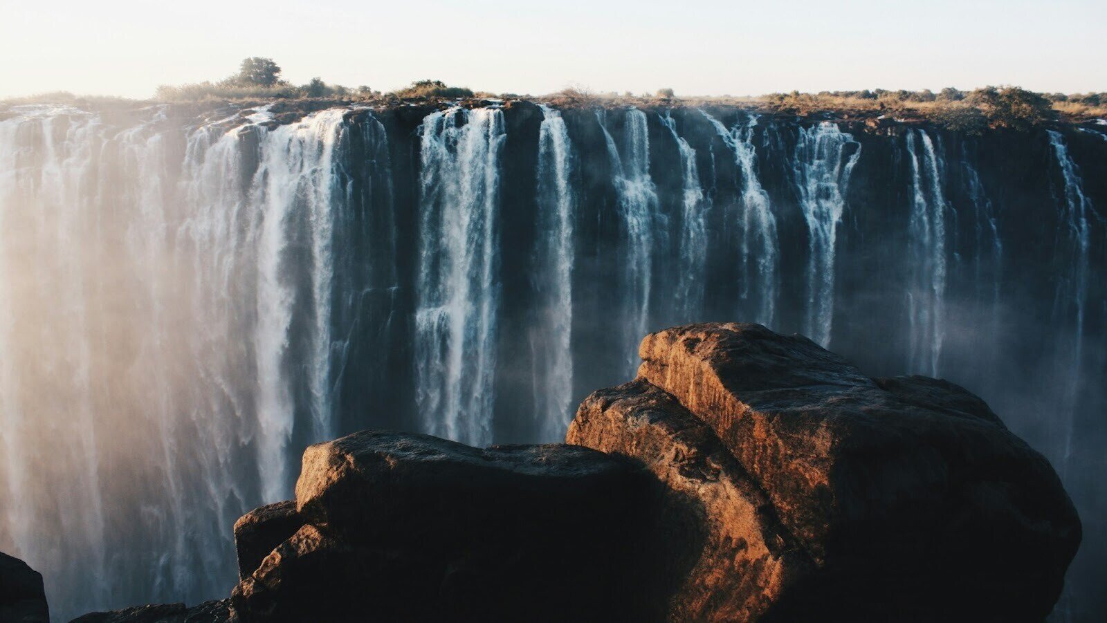Water falls on brown mountain in Victoria falls during daytime