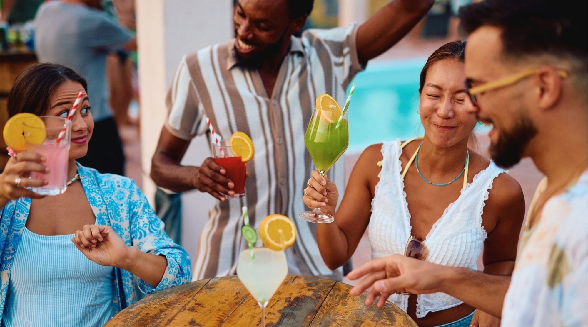 Grupo de amigos con cócteles en una pool party, ambiente de Spring Break.