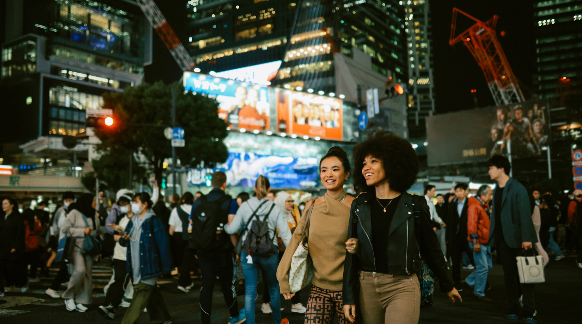 Gruppo di amiche in visita a Tokyo che usano lo smartphone per orientarsi e restare connesse durante il viaggio in Giappone
