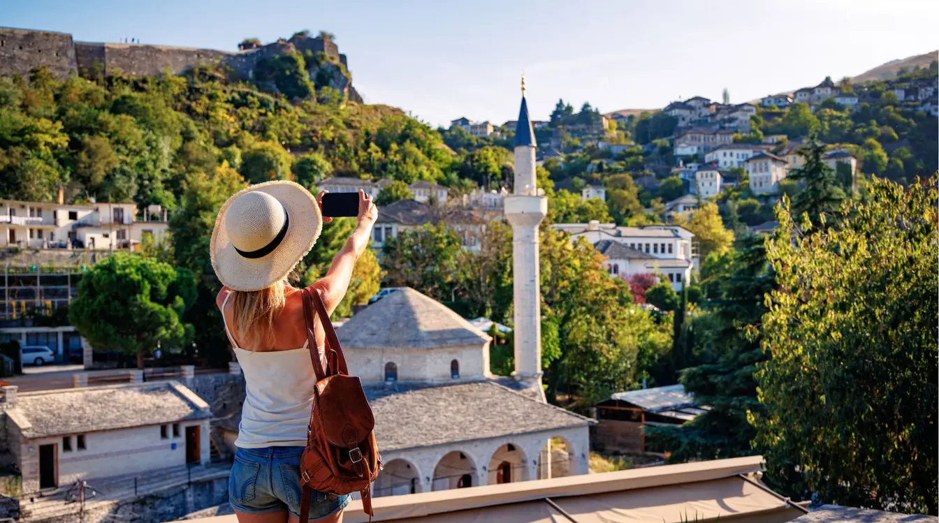Touriste prenant en photo une mosquée avec son smartphone lors de son voyage en Albanie.