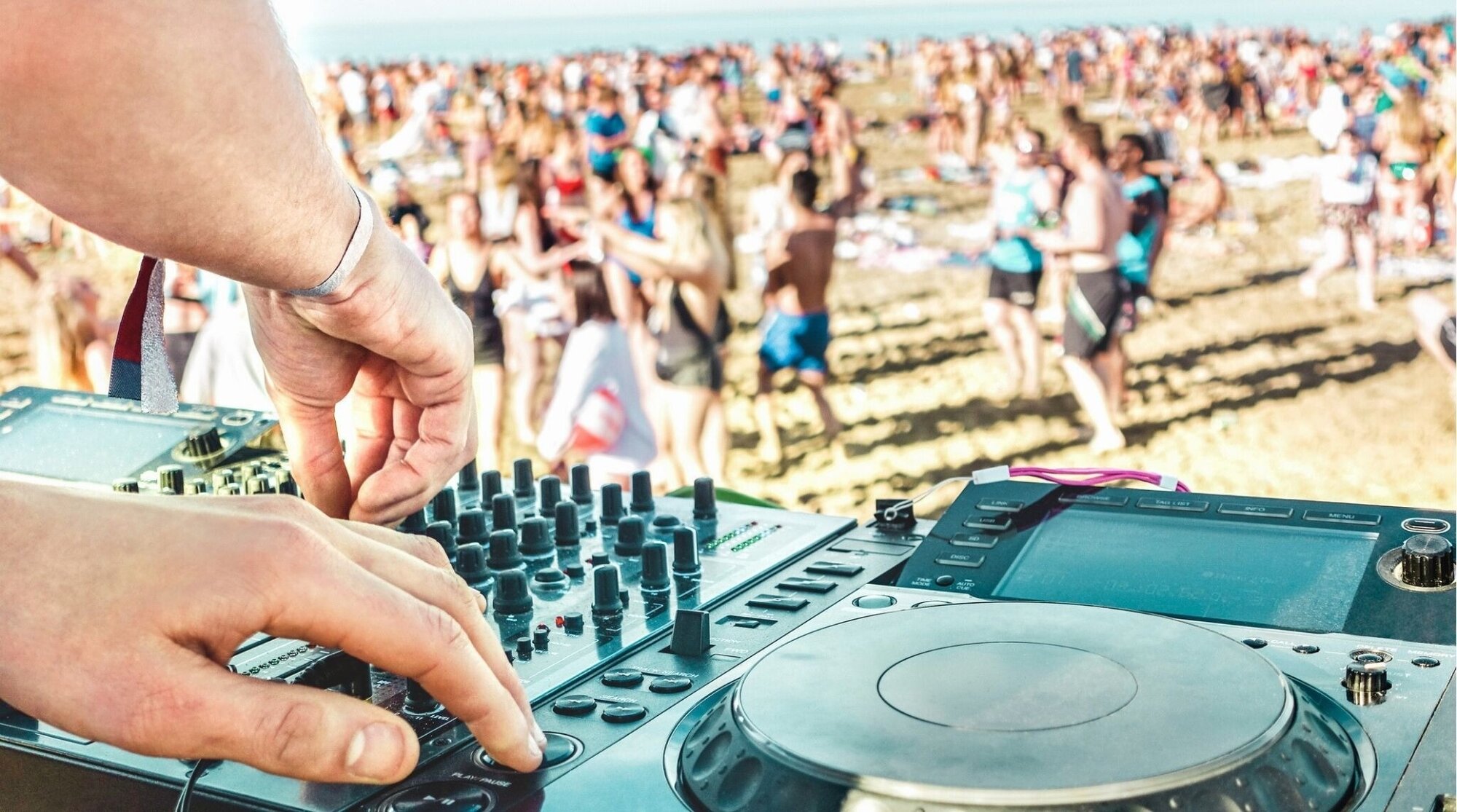 DJ pinchando en un festival al aire libre, ambiente de Spring Break.