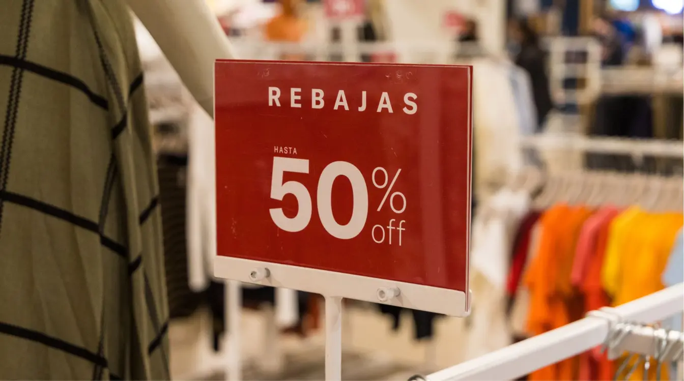 Vista em close-up de uma placa vermelha de “REBAJAS 50% OFF” em uma loja de Ciudad del Este, destacando promoções para compras no Paraguai.