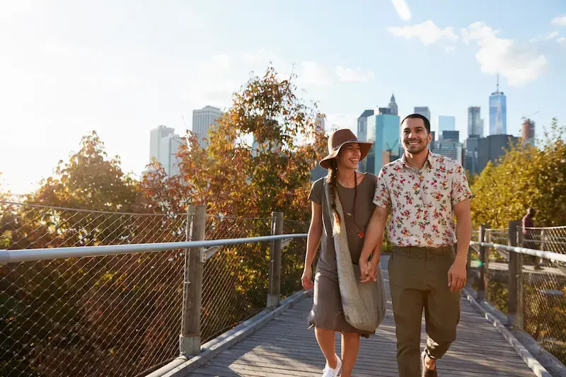 Pareja paseando en Nueva York con el horizonte de Manhattan al fondo durante un viaje a Estados Unidos.