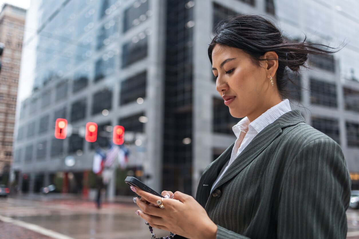 A woman in a city checking her texts