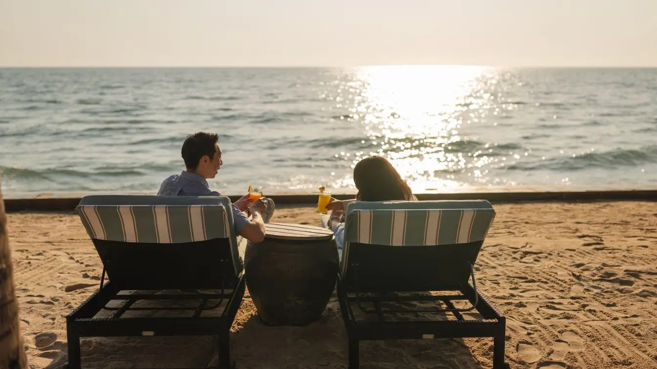 Ein Paar sitzt bei einem romantischen Urlaub am Strand in der Sonne