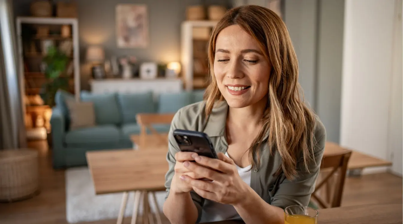Uma jovem usa um celular enquanto se prepara para o café da manhã.