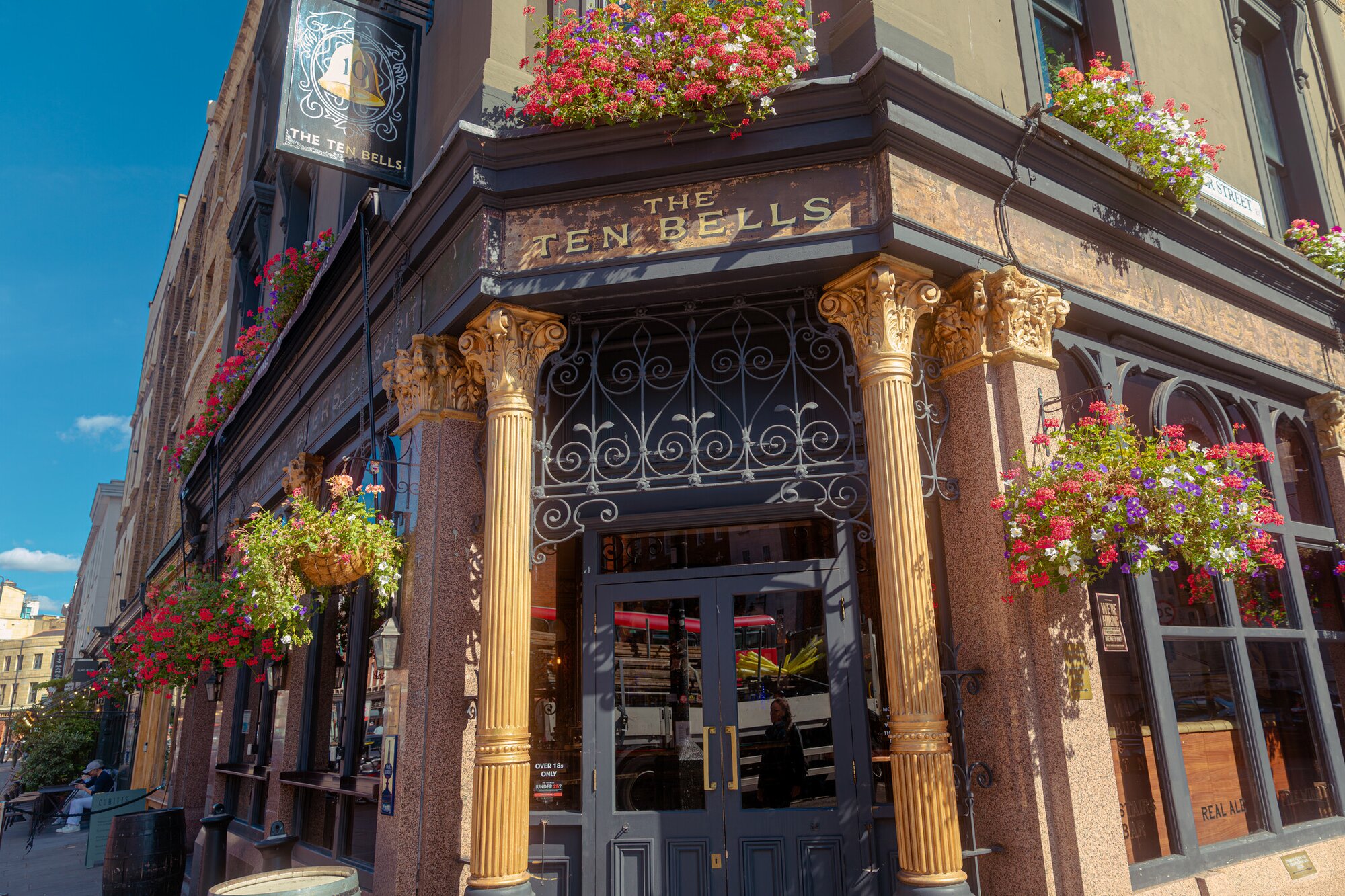 The exterior of the Ten Bells pub in London, with a golden column and flowers