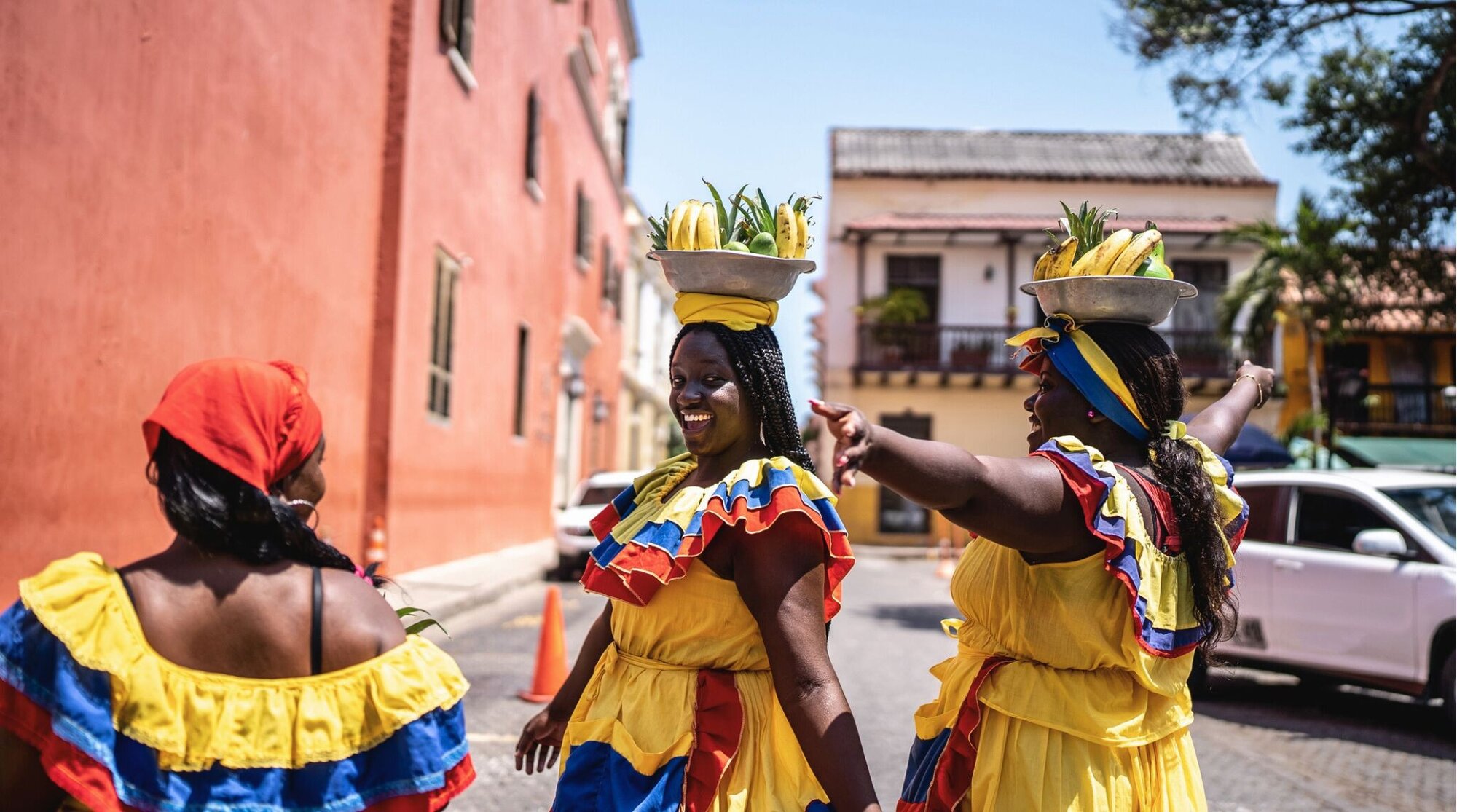 Palenqueras se divertem enquanto vendem frutas na rua em Cartagena.