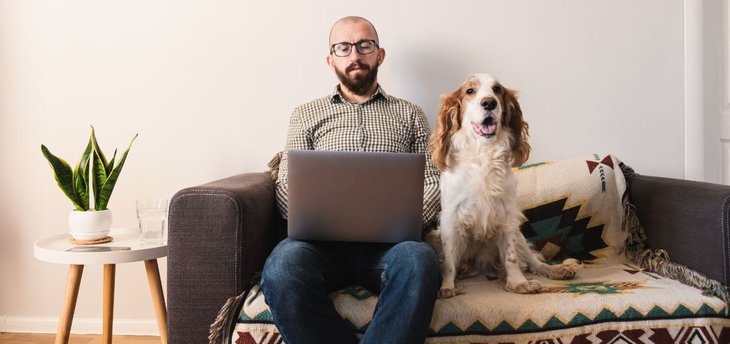 man sitting with dog on couch