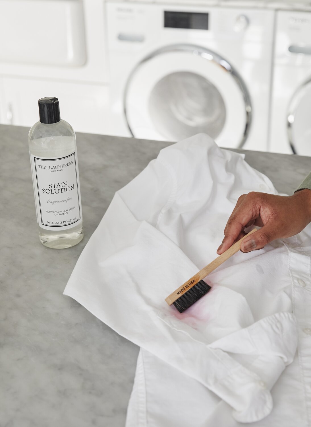 applying the laundress stain solution to white shirt