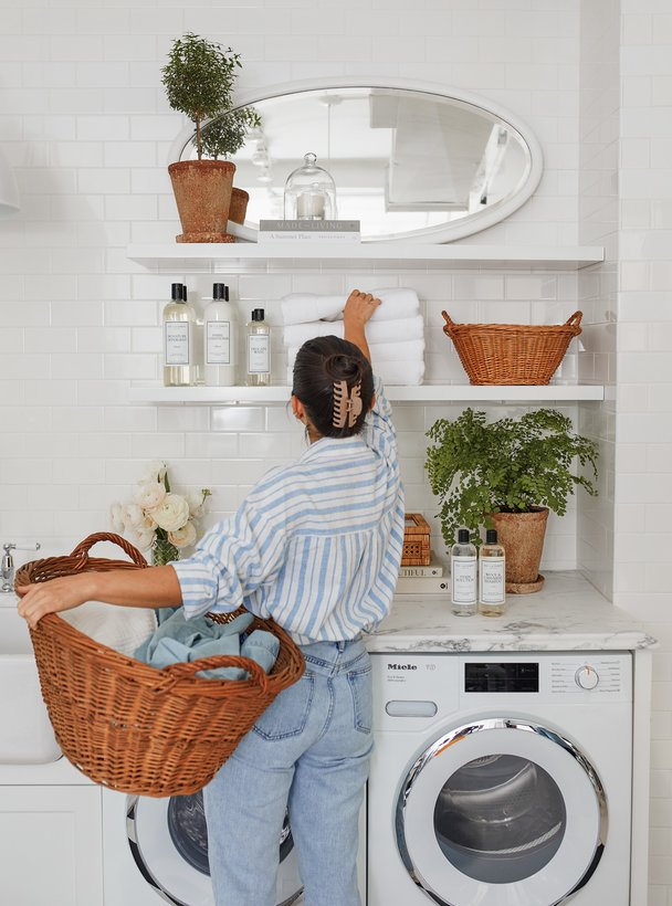 Woman reaching for towels on shelf