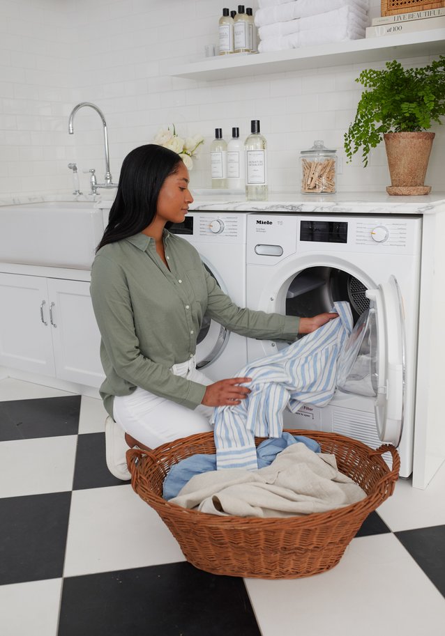 Woman loading laundry into washing machine