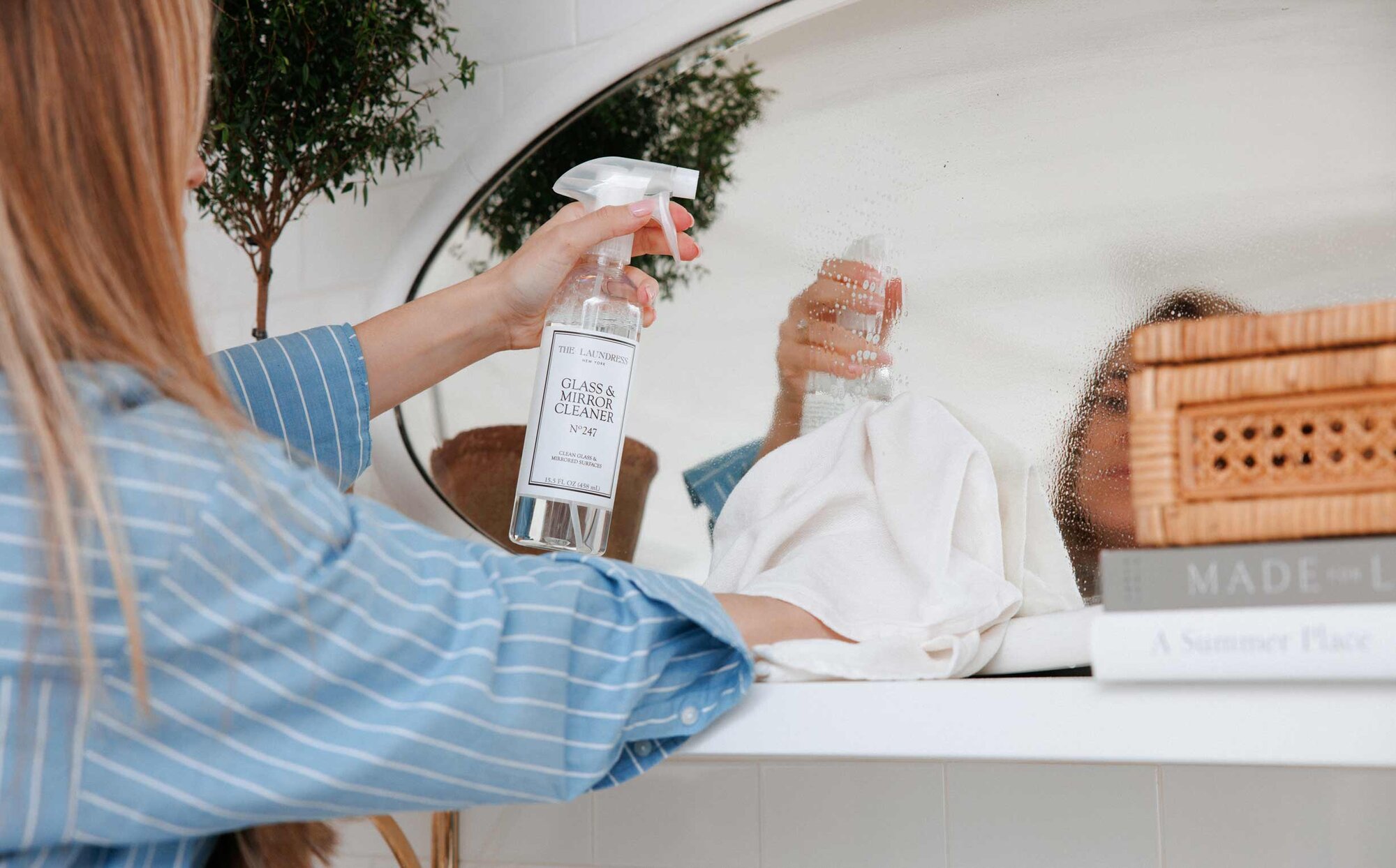 hand spraying mirror with glass and mirror cleaner