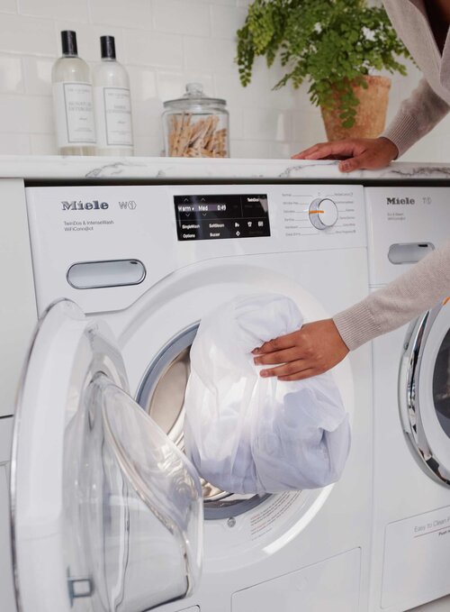 Woman placing mesh bags into washing machine