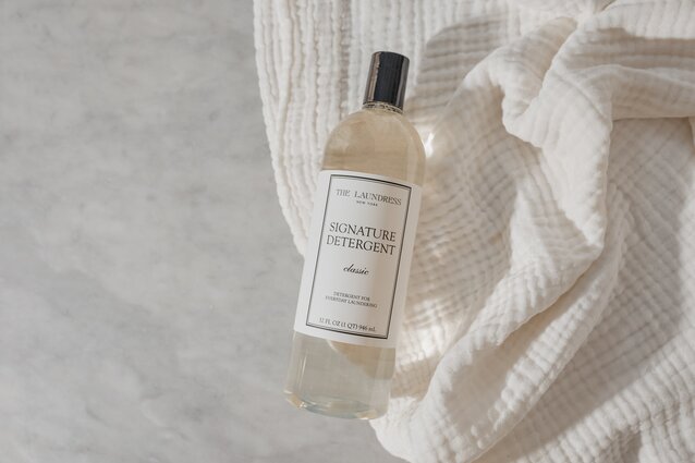 The Laundress Signature Detergent Classic for everyday laundering sitting on a white fabric