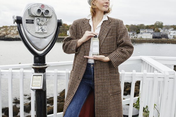 woman in coat holding the laundress wool & cashmere shampoo