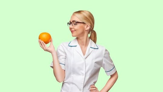 doctor holding 2 apples with green background