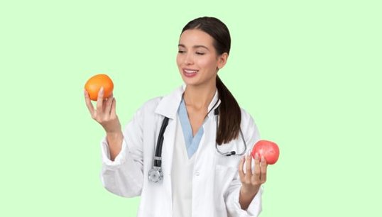 doctor holding 2 apples with green background