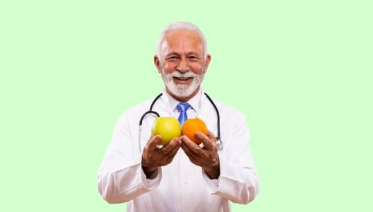 doctor holding 2 apples with green background