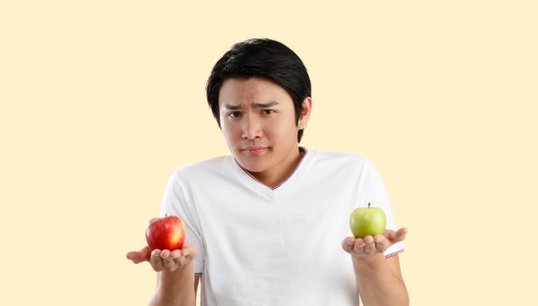 Man holding apple with pink background