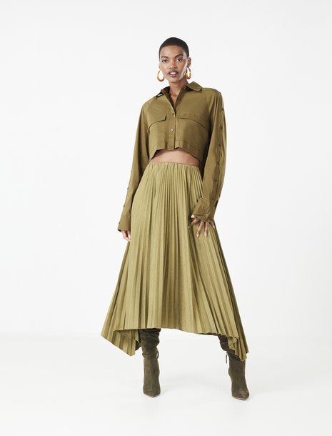 Picture of a woman in an olive green pleated skirt and button down crop top