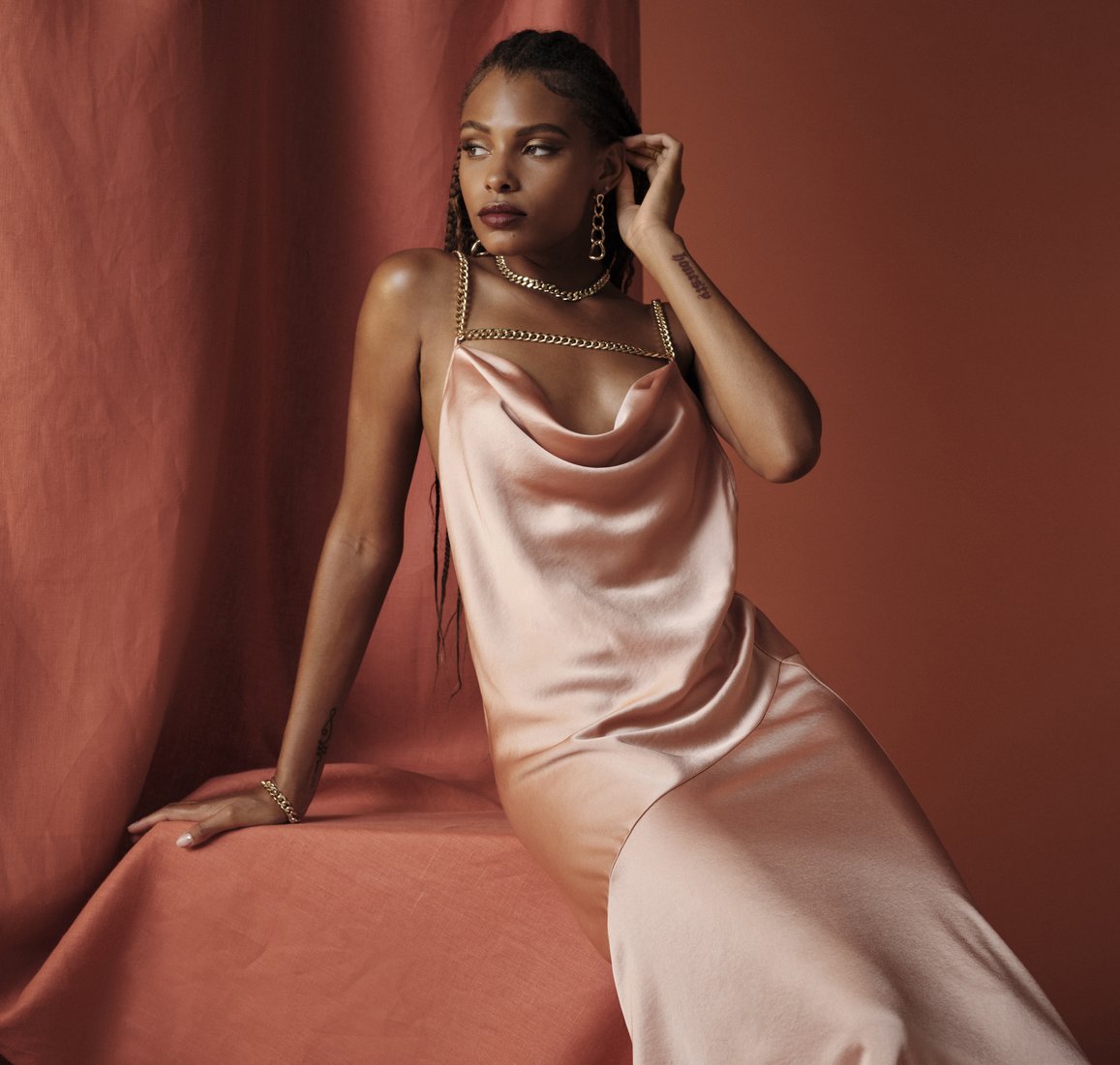 woman in silky satin pink maxi dress with cowl neck and chain details