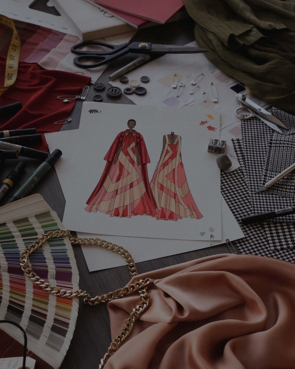 desktop with fashion sketch of woman in red maxi dress