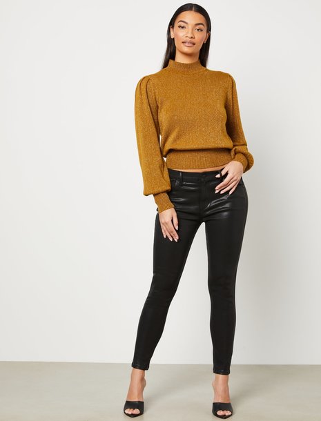Picture of a woman wearing a mustard sweater and jeans