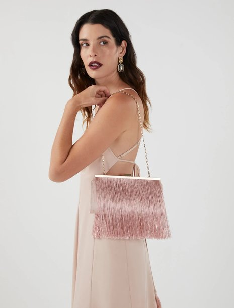 Woman holding a pink fringe clutch bag