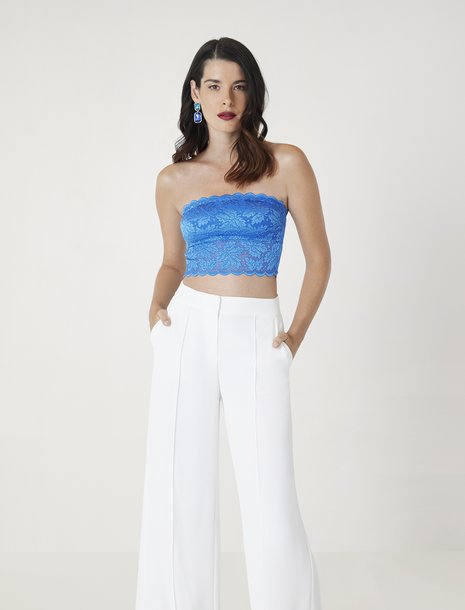 Picture of a women in white trousers and a bright blue bandeau