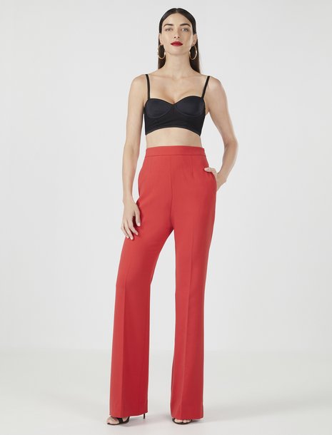 Picture of a woman in a black bralette and a bright red flared trouser pant