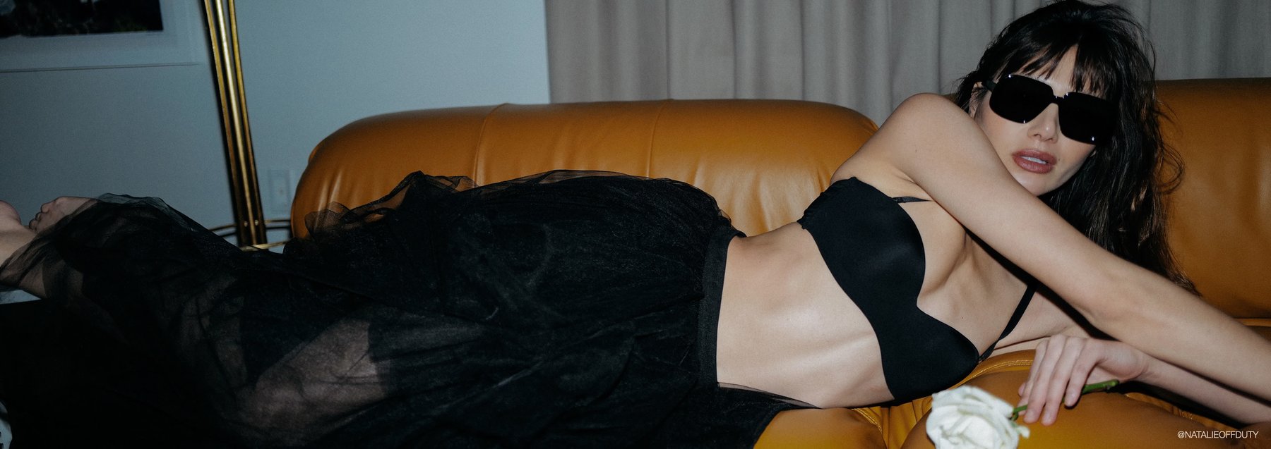 influencer model natalie lim suarez wearing a black bra and black tulle maxi skirt and large black sunglasses
