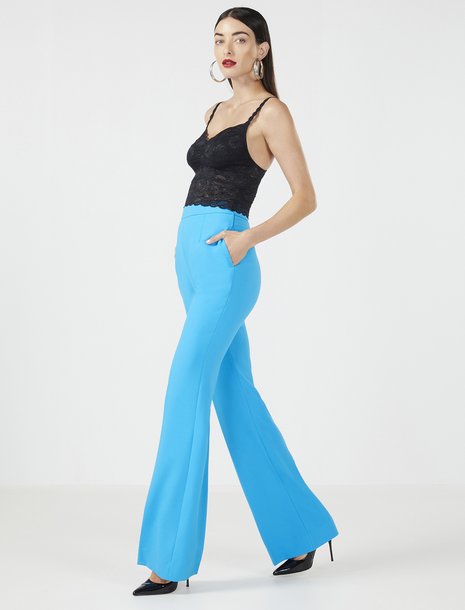 Picture of a woman in a black lace bodysuit and a bright blue flared trouser pant